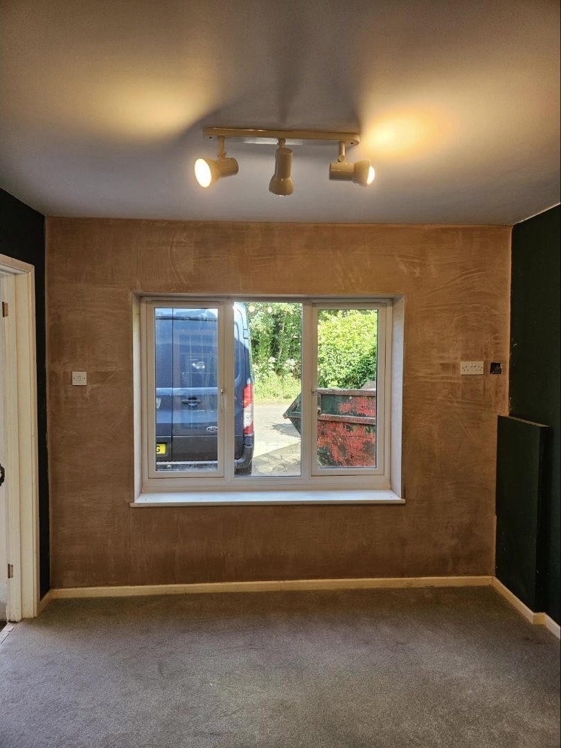 Completed garage conversion in Swindon - plastered and carpeted habitable room with a new double-glazed window where the garage door used to be