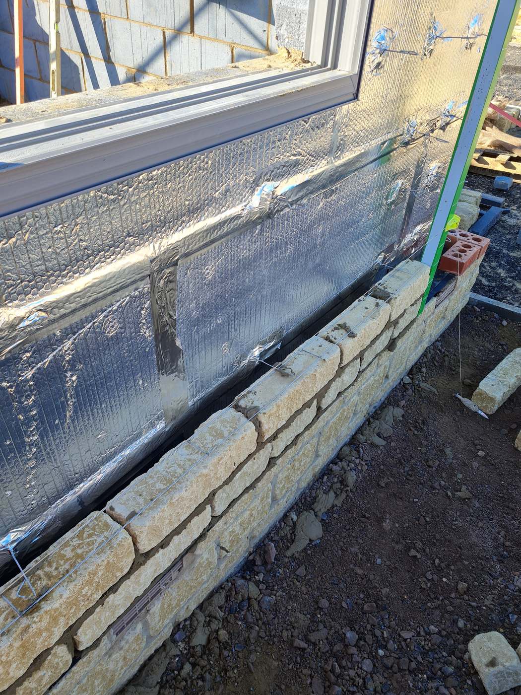 Natural stone cavity walling built off an insulated slab by SwiftBrick