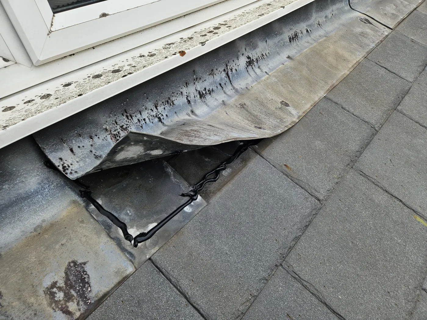 Failed and split lead flashing under the window sill
