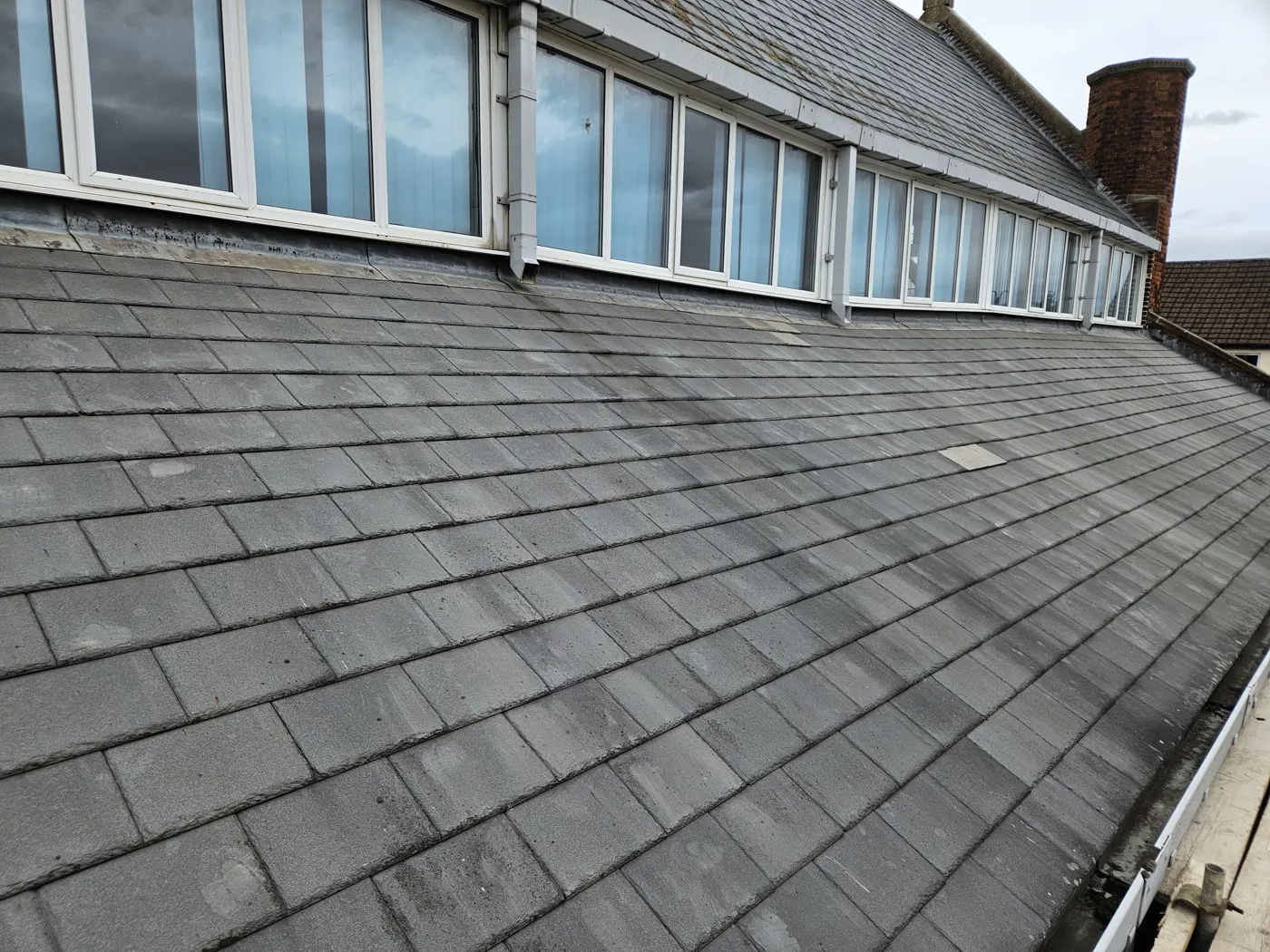 Retiled roof slope below clerestory windows on a church hall in Gorse Hill, Swindon