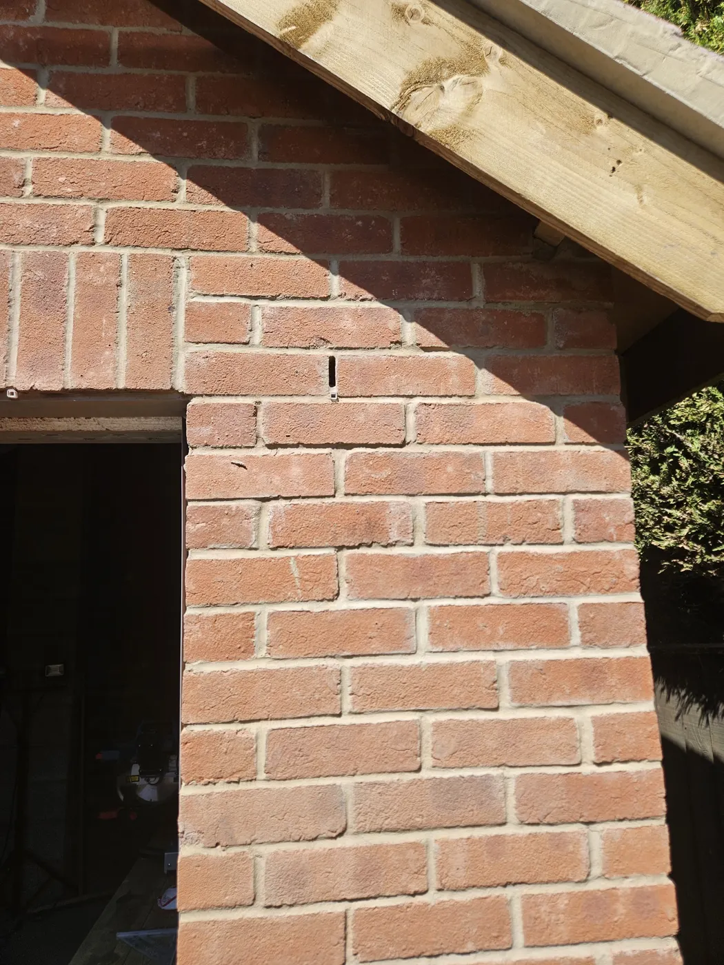 Corner of the new brick garden building with the roof structure above