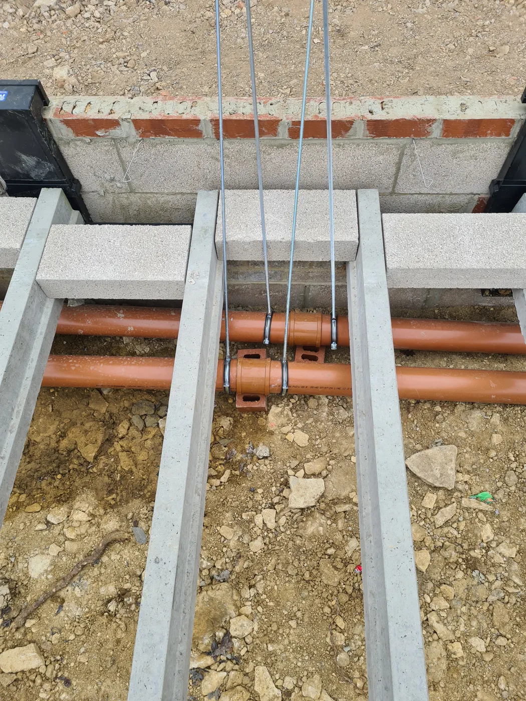 Precast concrete floor beams over the foundations with drainage below