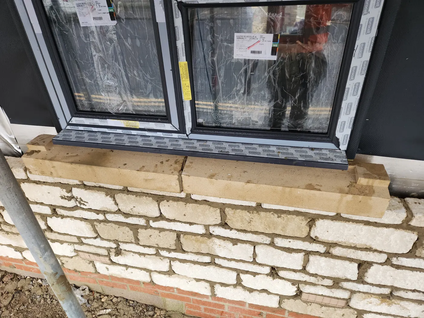 Beckstone walling under a new window on the new-build houses