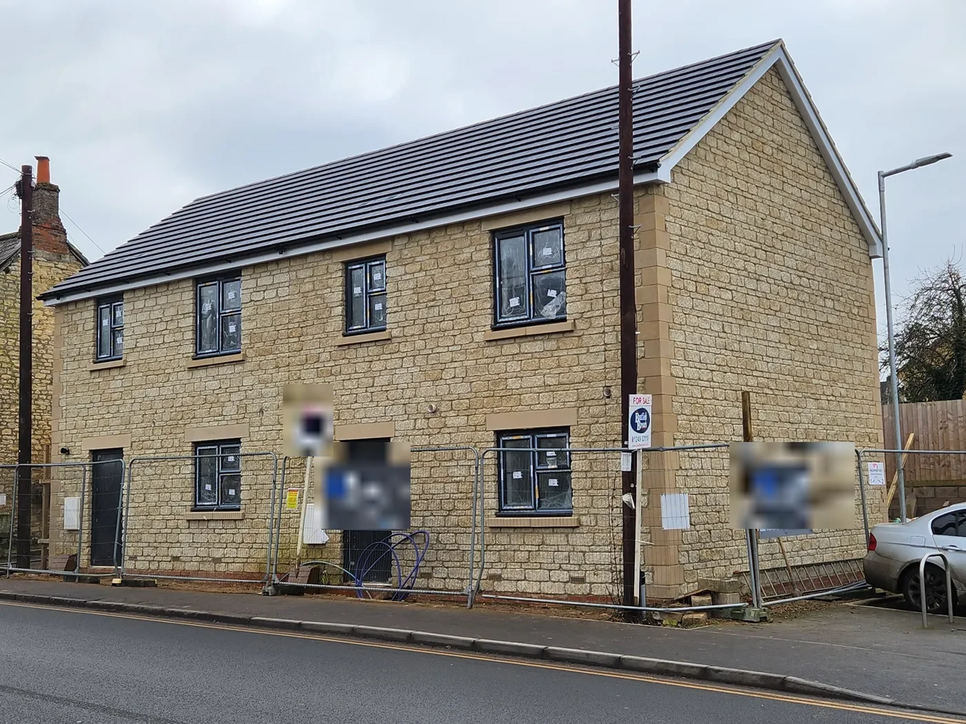 Completed pair of new-build stone-faced semi-detached houses on London Road, Calne