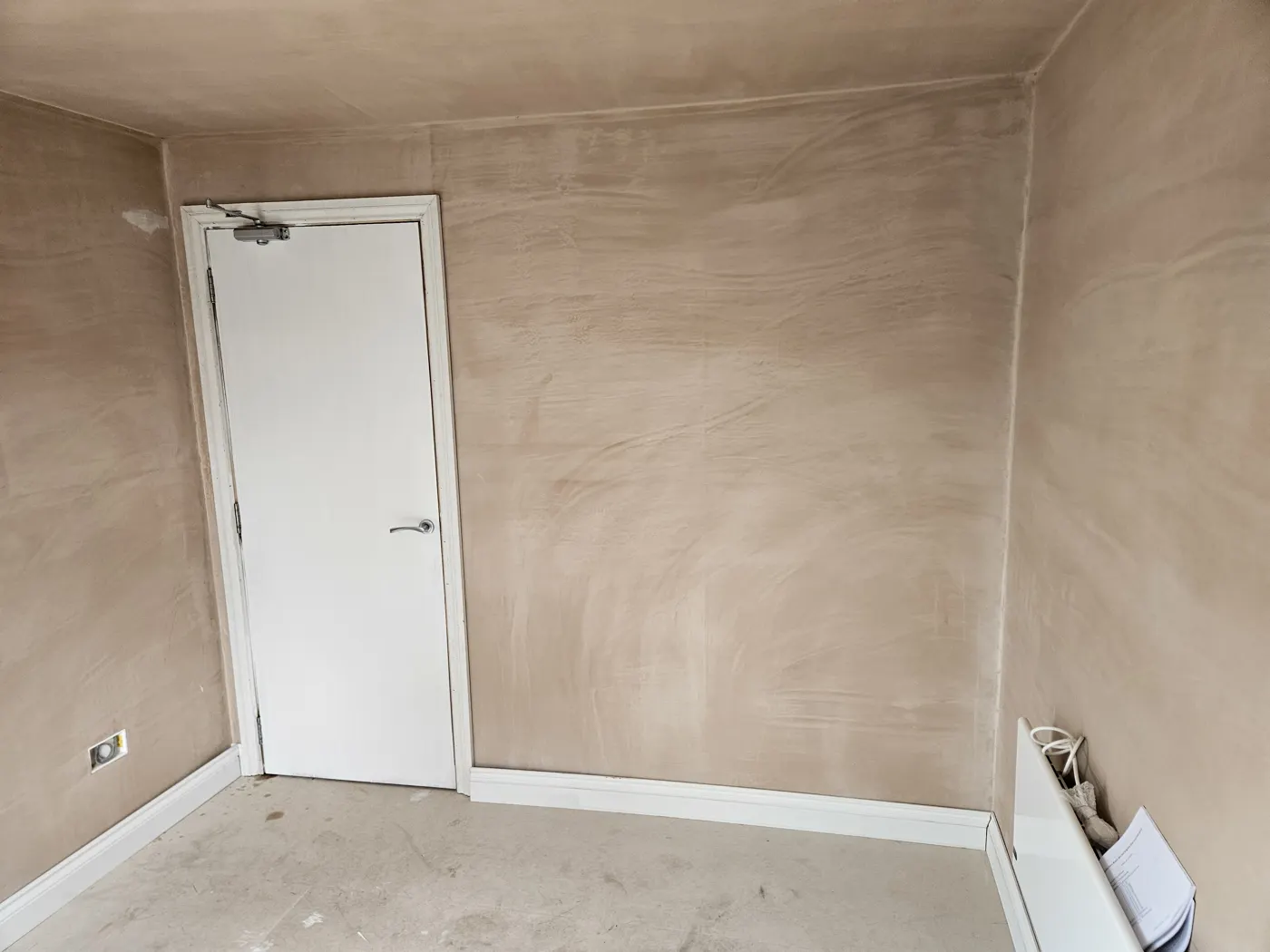 Plastered room with the door to the house