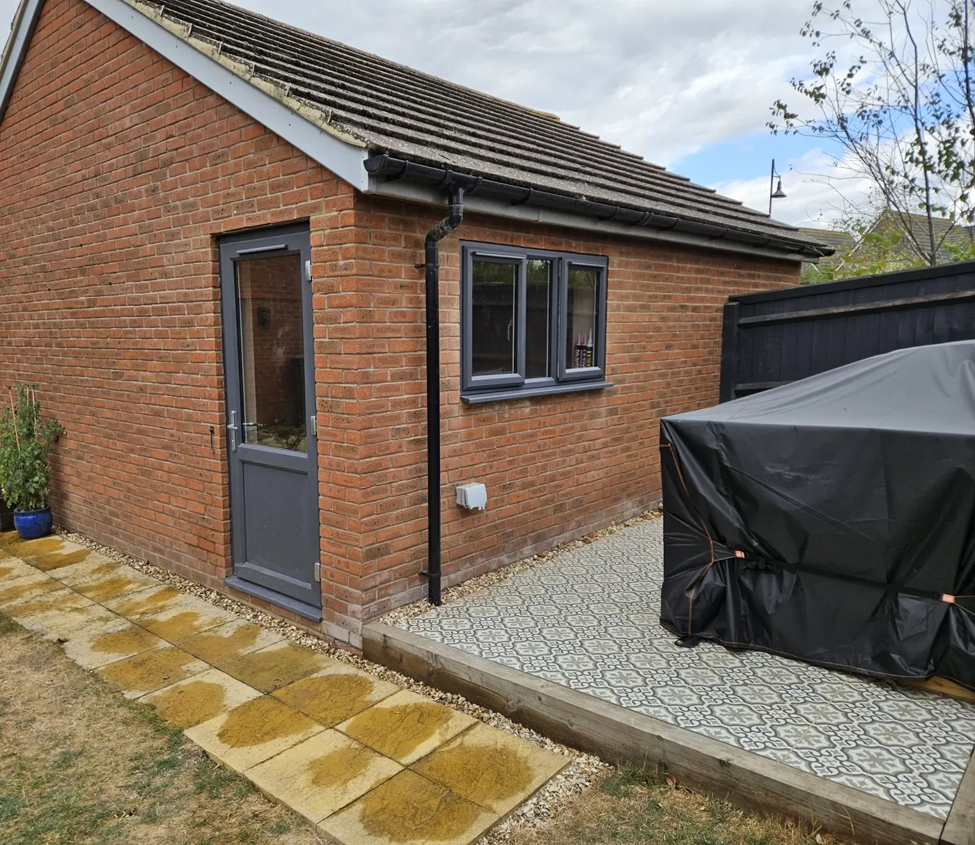 Front of the house after conversion showing the retained half garage door and new window