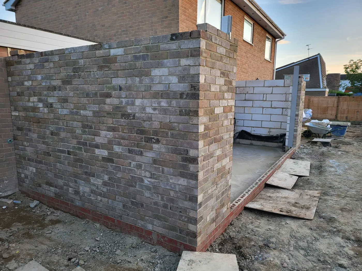 Reclaimed-brick cavity walls of the extension rising beside the house
