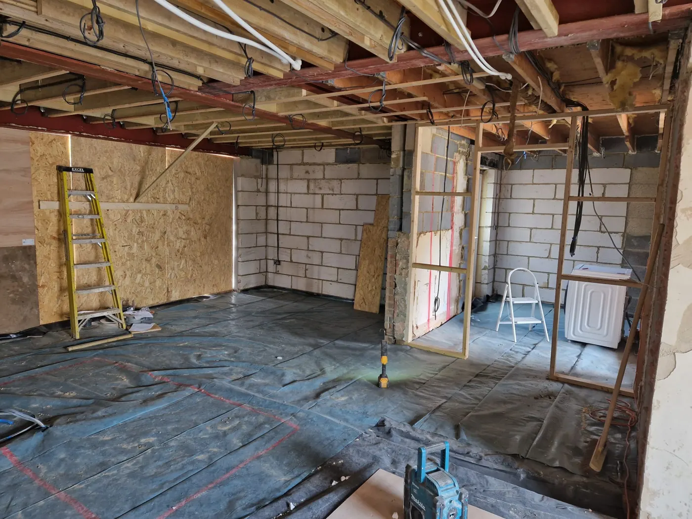 Inside the ground floor with steel beams installed and ceilings exposed