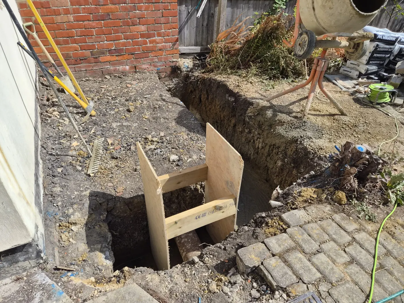 Excavated foundation trench with timber shuttering beside the house