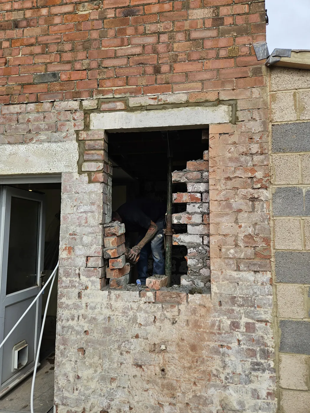 Structural opening being formed through the original rear wall of the house