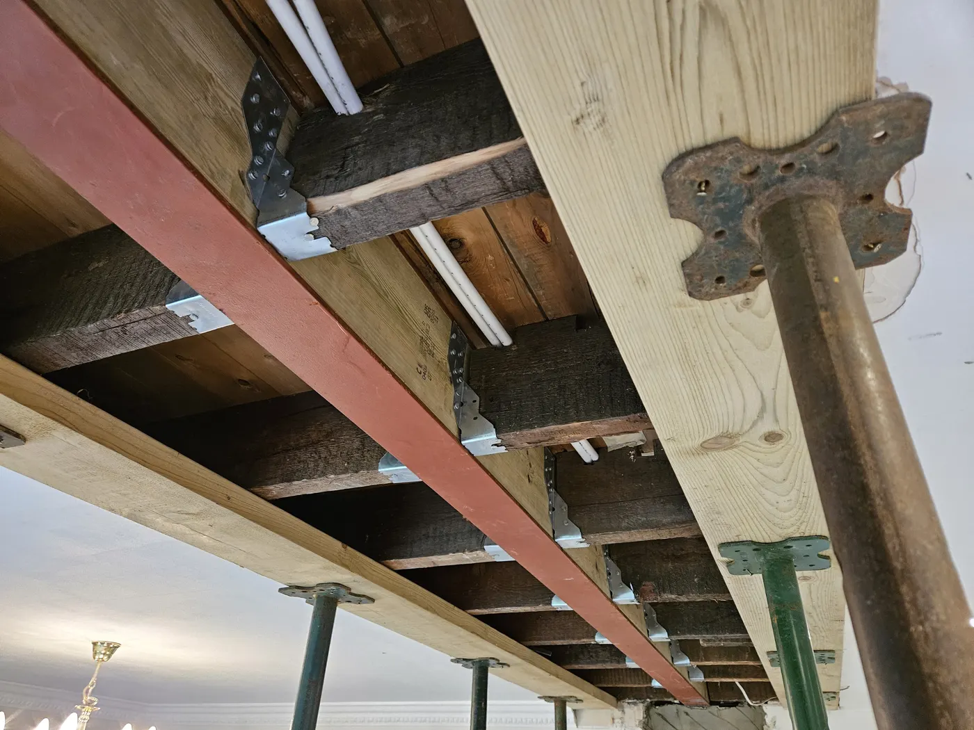 New steel beam in place with temporary props still supporting the floor above