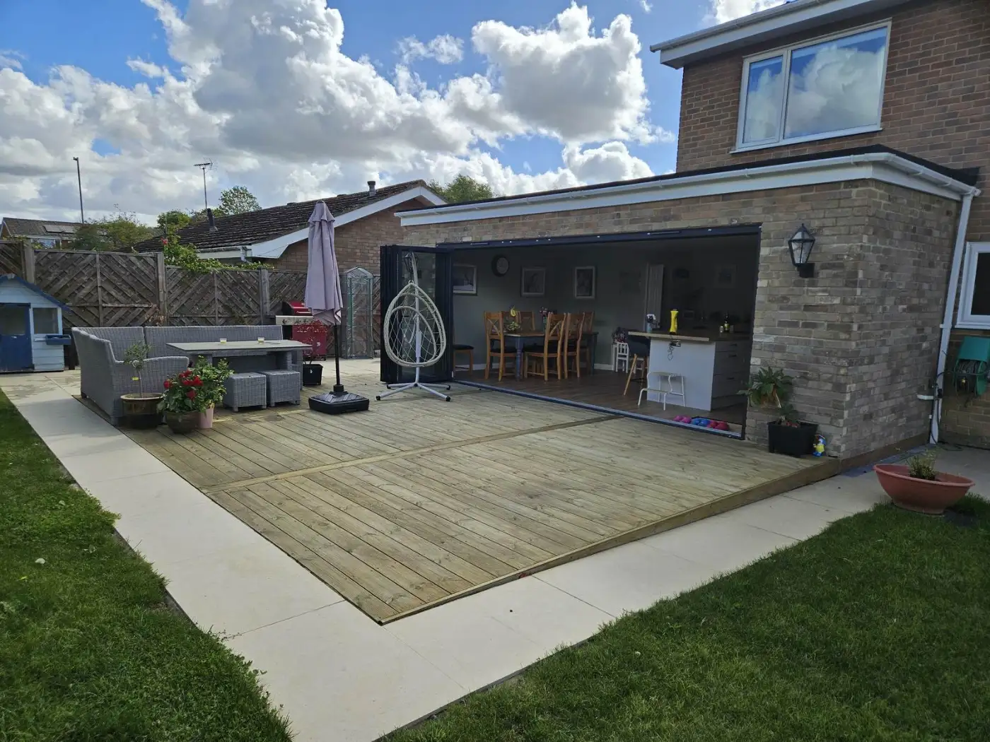 Completed single-storey rear house extension in Swindon with bifold doors and new decking